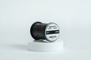 Iris thread spool with iridescent multicolor thread on a white pedestal, labeled veevus iris